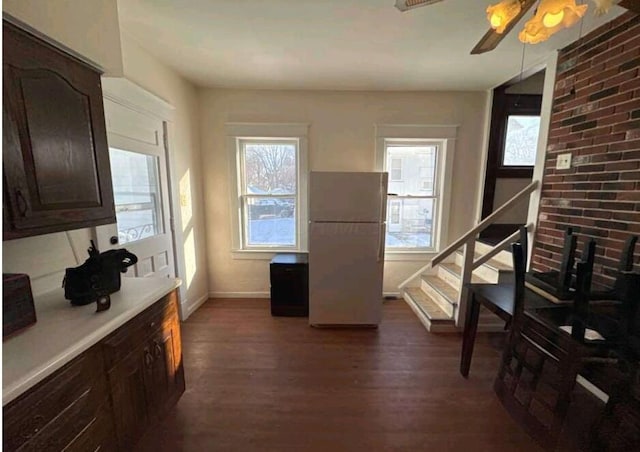 kitchen featuring dark wood-type flooring, dark brown cabinets, ceiling fan, and freestanding refrigerator
