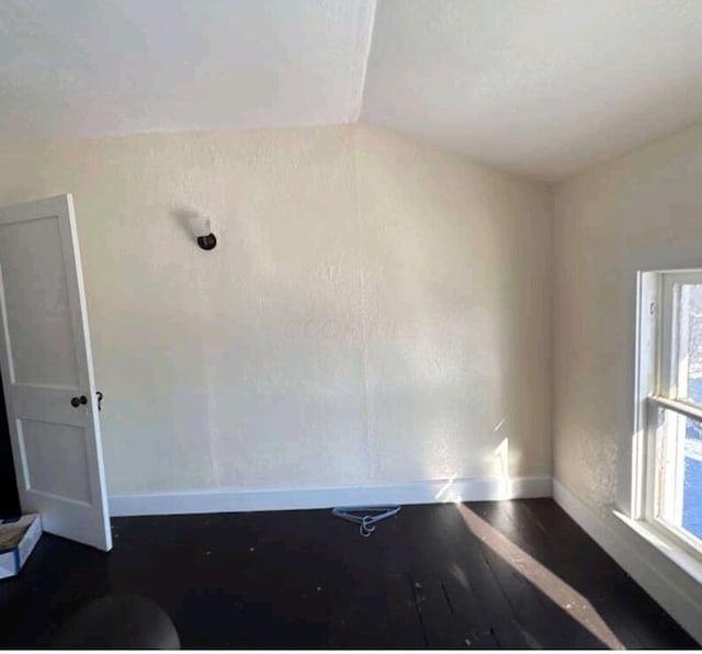 empty room featuring dark wood-type flooring and baseboards