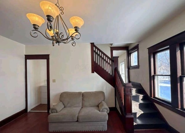 stairs with baseboards, wood finished floors, and a chandelier