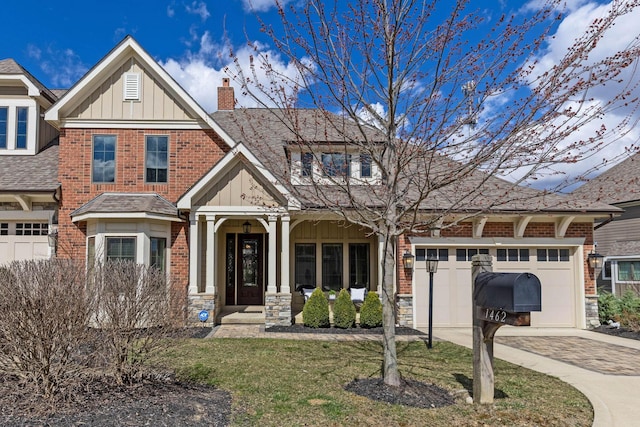 1462 Dogwood Loop, Powell, OH 43065 - view of front facade with board and batten siding, brick siding, driveway, and a garage