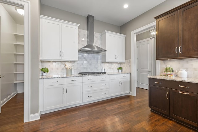 1462 Dogwood Loop, Powell, OH 43065 - kitchen featuring white cabinetry, stainless steel gas cooktop, dark wood finished floors, wall chimney range hood, and dark brown cabinetry
