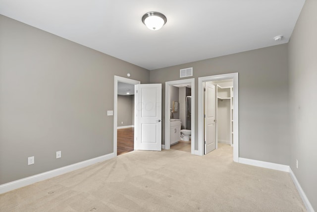 1462 Dogwood Loop, Powell, OH 43065 - unfurnished bedroom featuring a spacious closet, baseboards, light colored carpet, and visible vents
