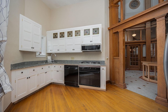 108 W Main St, Glenford, OH 43739 - kitchen with white cabinetry, black appliances, light wood-type flooring, and a sink