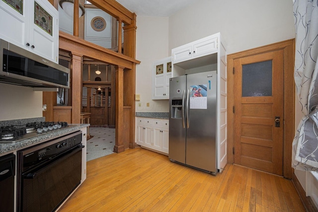 108 W Main St, Glenford, OH 43739 - kitchen with white cabinets, light wood-style flooring, and appliances with stainless steel finishes