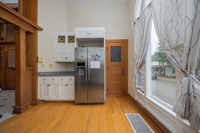 108 W Main St, Glenford, OH 43739 - kitchen with light wood finished floors, visible vents, stainless steel fridge, and white cabinets