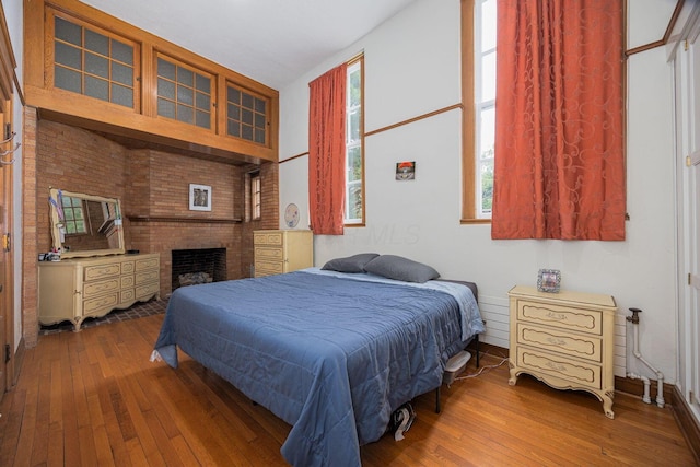 108 W Main St, Glenford, OH 43739 - bedroom featuring a brick fireplace and wood-type flooring