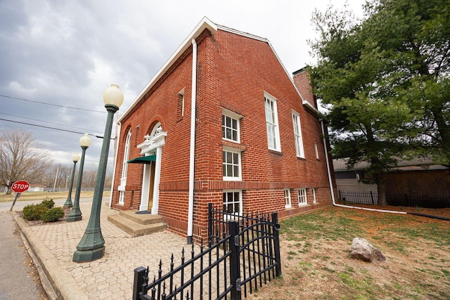 108 W Main St, Glenford, OH 43739 - view of side of property featuring brick siding, a chimney, and fence