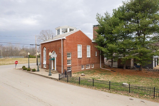 108 W Main St, Glenford, OH 43739 - view of side of property with driveway, a chimney, entry steps, a fenced front yard, and brick siding