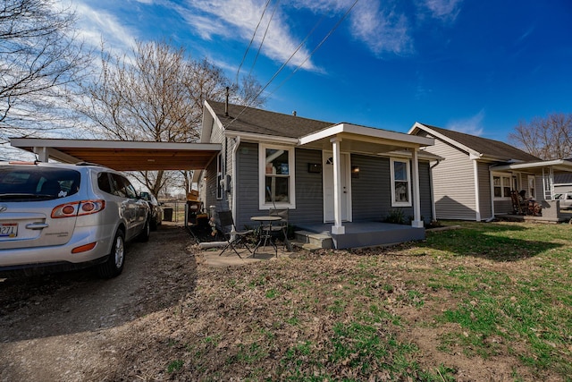 view of front of house with an attached carport, covered porch, and a front yard