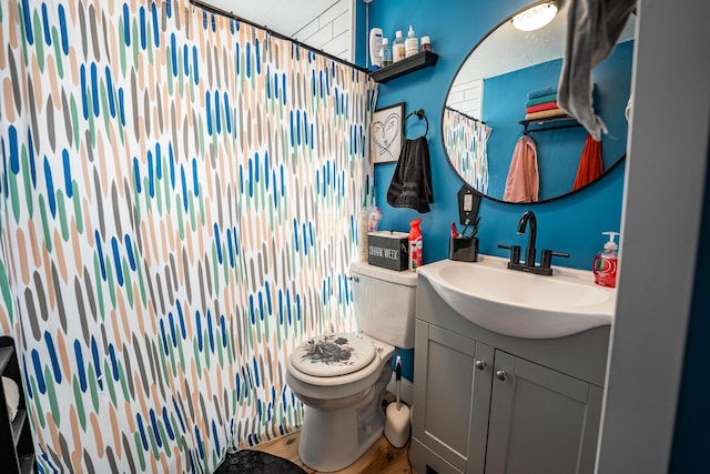 full bath with curtained shower, toilet, wood finished floors, and vanity