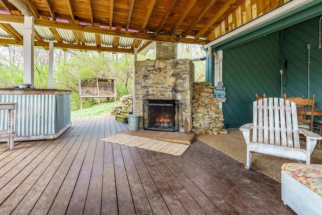 wooden deck featuring an outdoor stone fireplace