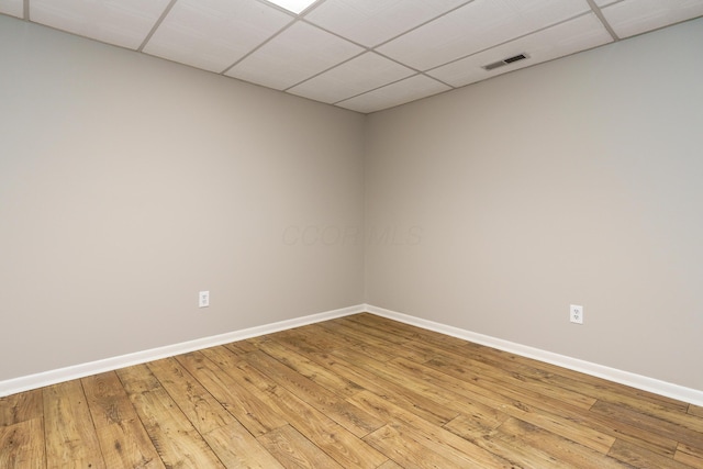 unfurnished room with visible vents, a paneled ceiling, light wood-style flooring, and baseboards