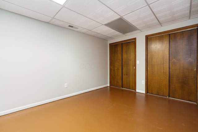 unfurnished bedroom featuring visible vents, two closets, concrete flooring, and baseboards