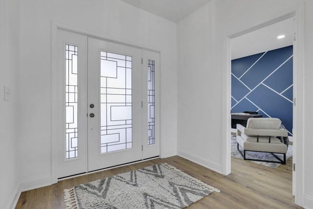 foyer entrance featuring baseboards and wood finished floors