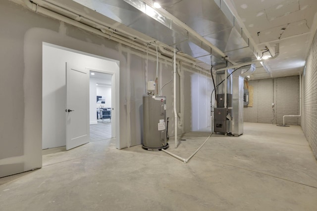 unfinished basement with heating unit, electric water heater, and brick wall