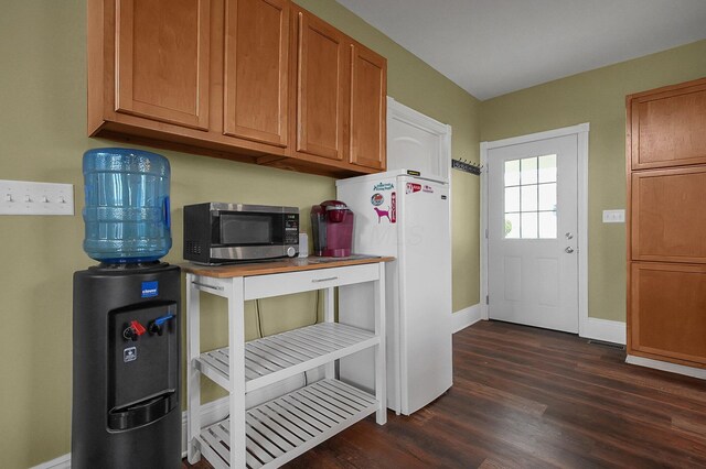19643 Big Pine Rd, Laurelville, OH 43135 - kitchen with dark wood-style floors, baseboards, freestanding refrigerator, stainless steel microwave, and brown cabinets