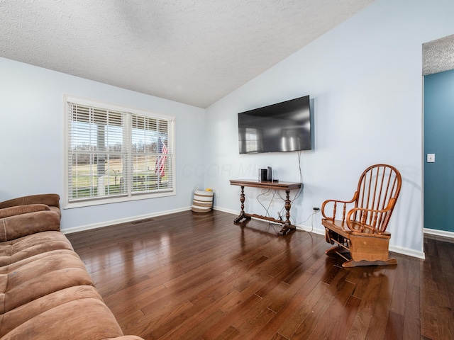 sitting room featuring lofted ceiling, a textured ceiling, and hardwood / wood-style flooring