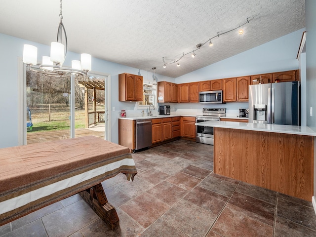 kitchen featuring brown cabinets, appliances with stainless steel finishes, light countertops, and a sink