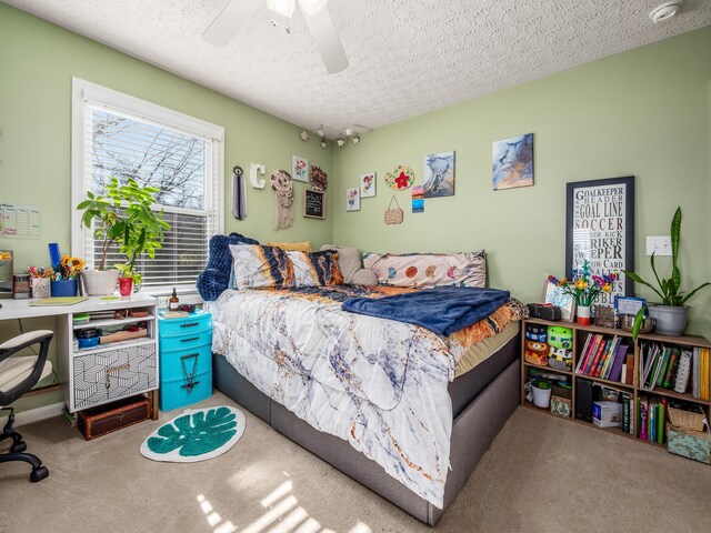 bedroom featuring carpet flooring, a ceiling fan, and a textured ceiling