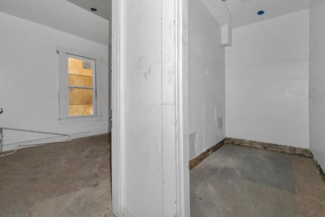 bathroom with baseboards and unfinished concrete floors