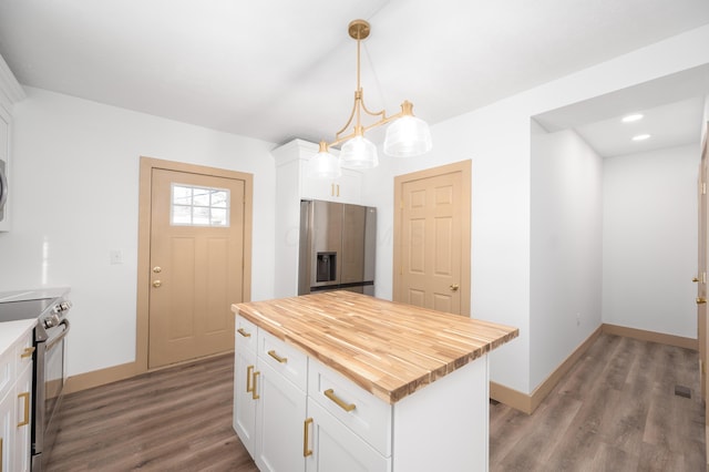 kitchen featuring white cabinets, wood finished floors, appliances with stainless steel finishes, and butcher block countertops
