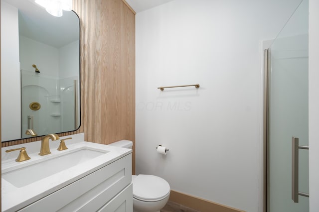 bathroom featuring a shower, baseboards, toilet, and vanity