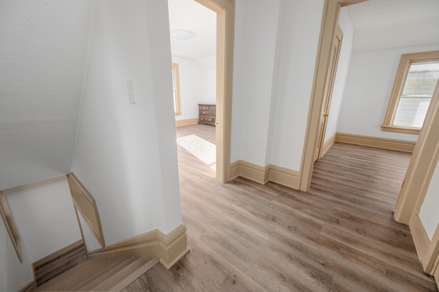 hall featuring baseboards and wood finished floors