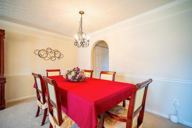 dining room featuring arched walkways, carpet, baseboards, and ornamental molding