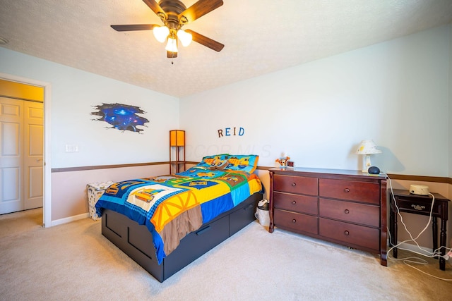 carpeted bedroom with baseboards, a ceiling fan, and a textured ceiling