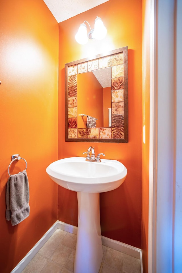 bathroom with a sink and baseboards