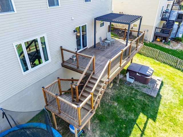 wooden terrace featuring a lawn, stairs, fence, and a hot tub