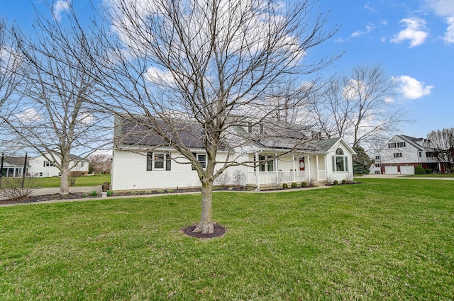 view of front of property with covered porch, a garage, and a front yard