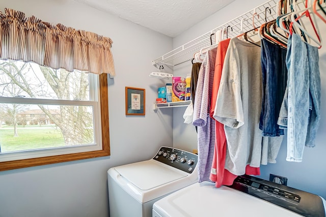 washroom featuring separate washer and dryer, laundry area, and a textured ceiling