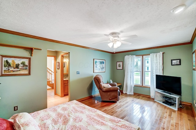 bedroom featuring baseboards, a textured ceiling, crown molding, and light wood finished floors