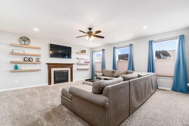 living area with carpet floors, ceiling fan, and a healthy amount of sunlight