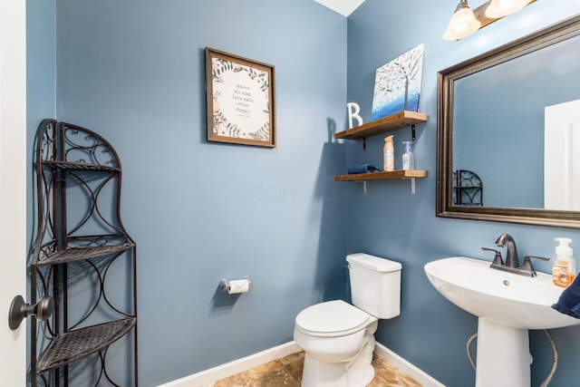 half bathroom with toilet and baseboards