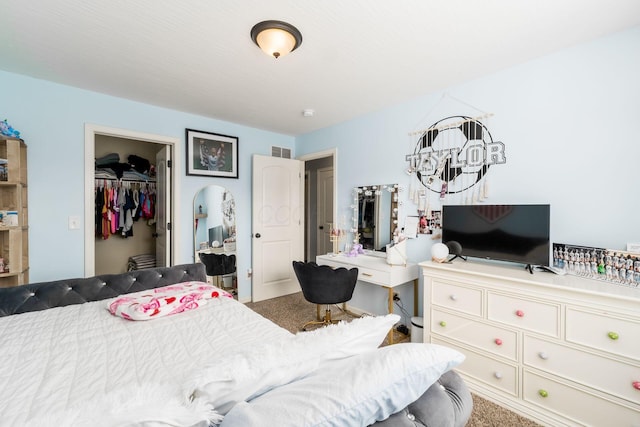 carpeted bedroom with a closet, visible vents, and a spacious closet