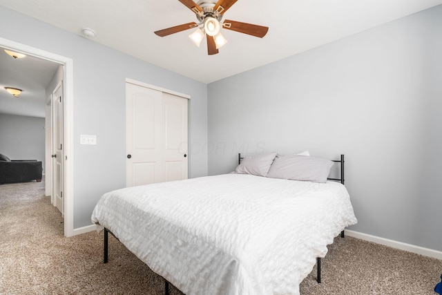 bedroom with a ceiling fan, light carpet, baseboards, and a closet