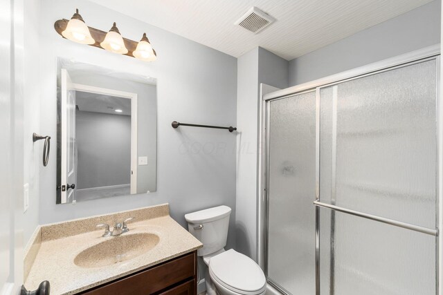 full bath with visible vents, a stall shower, toilet, and vanity