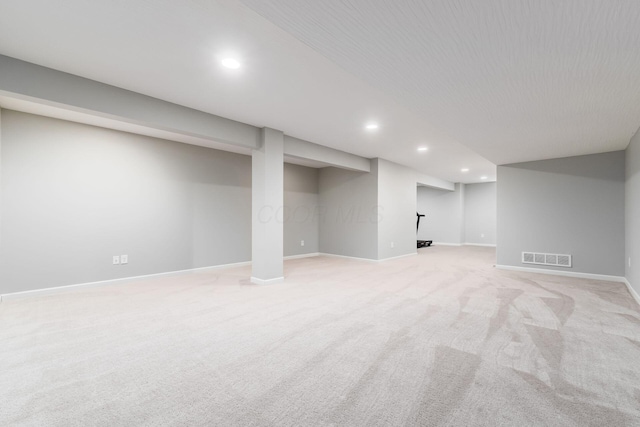 finished basement featuring baseboards, visible vents, recessed lighting, and light carpet