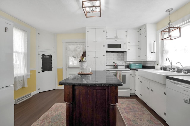 28 John St, Mount Sterling, OH 43143 - kitchen featuring white appliances, dark wood-style flooring, white cabinets, and decorative backsplash