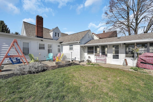 28 John St, Mount Sterling, OH 43143 - rear view of property featuring a lawn, a chimney, roof with shingles, and a patio