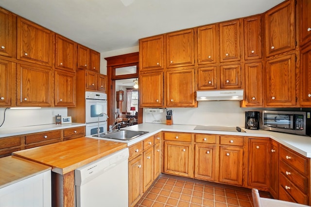 4175 Reynoldsburg Baltimore Rd NW, Baltimore, OH 43105 - kitchen with a sink, white appliances, brown cabinets, under cabinet range hood, and light tile patterned floors
