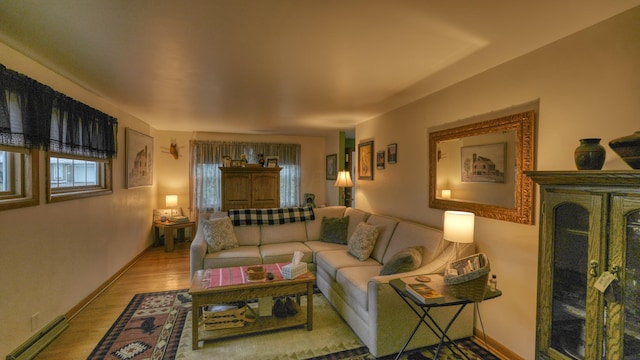 living area with baseboard heating, baseboards, and wood finished floors