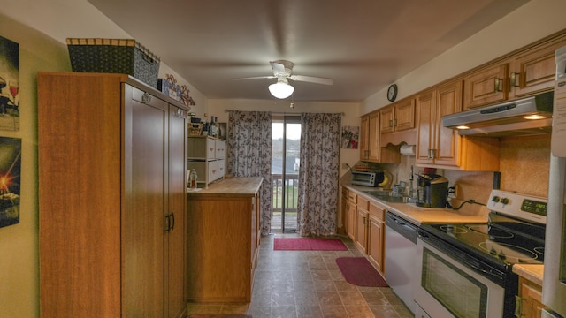 kitchen with a sink, ceiling fan, light countertops, under cabinet range hood, and appliances with stainless steel finishes