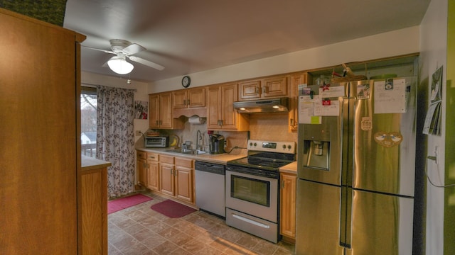 kitchen with under cabinet range hood, a sink, appliances with stainless steel finishes, light countertops, and ceiling fan