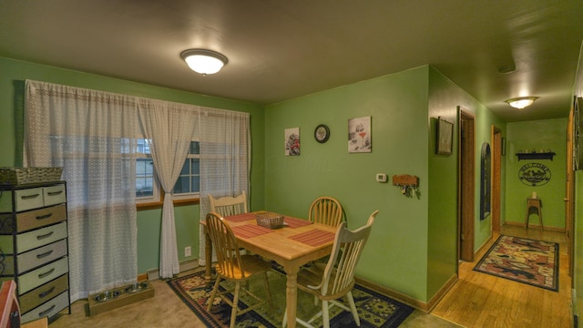 dining space featuring baseboards and wood finished floors