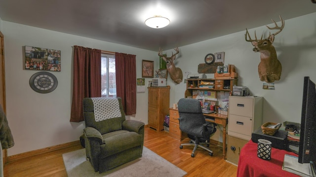 home office with light wood-style flooring and baseboards