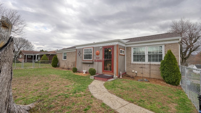 bungalow with a front yard, a fenced backyard, and brick siding