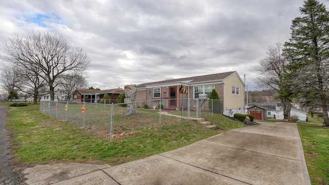 bungalow featuring a fenced front yard, a garage, an outbuilding, and a front yard